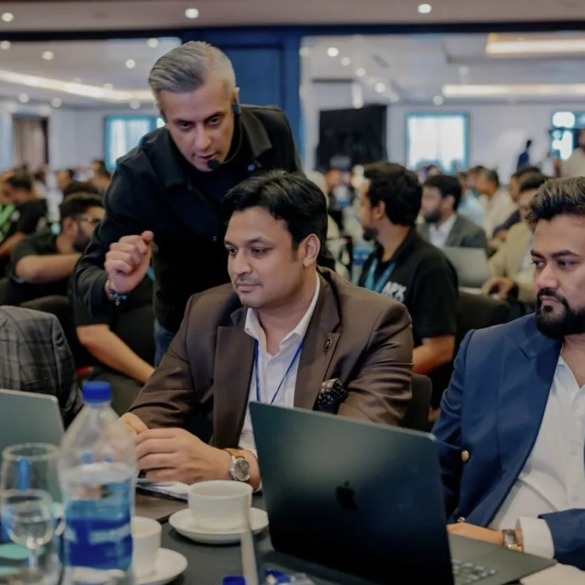 Raj Goodman Anand working through an AI exercise with delegates at their laptops