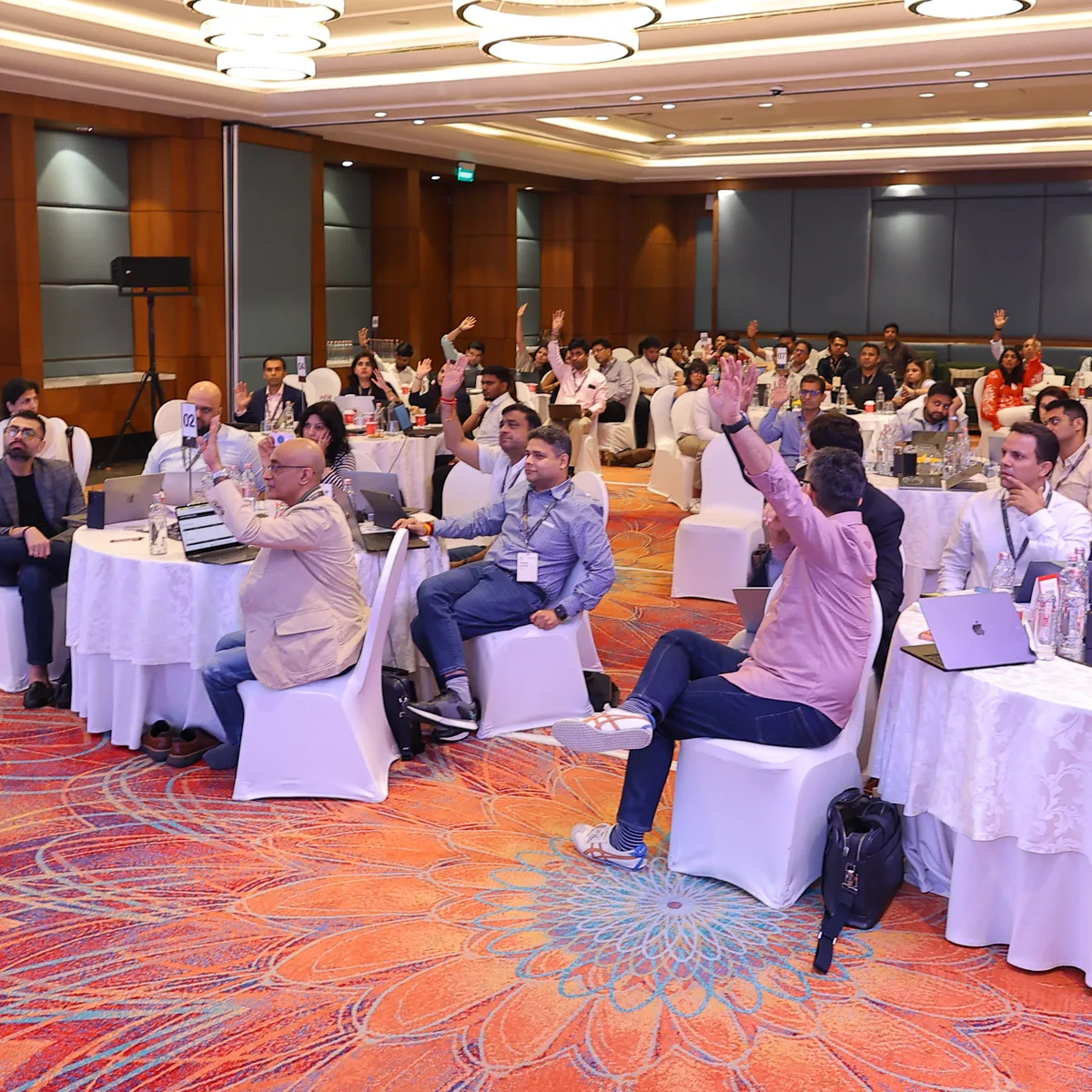 Delegates raising their hands during an interactive AI-First Mindset workshop