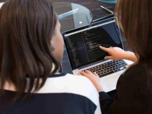 Two women collaborating on AI development